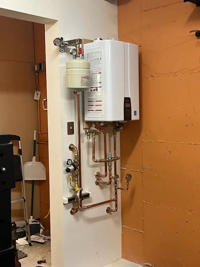 Plumbing technician inspecting water heater connections in Yorkville